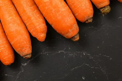 Грязная морковь в черной пластиковой коробке и одна вымытая морковь |  Премиум Фото
