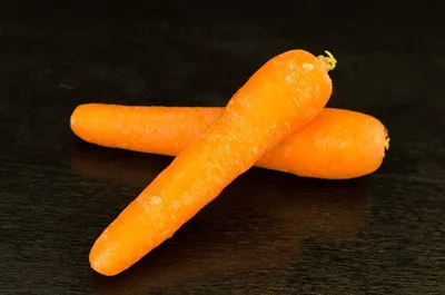 Сложенная морковь на черном столе с местом для текста | Премиум Фото