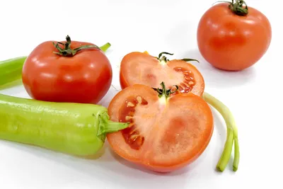 Летящие помидоры и острый перец чили на белом фоне. Левитация свежих  красных овощей. Изолированный - Ozero - российский фотосток