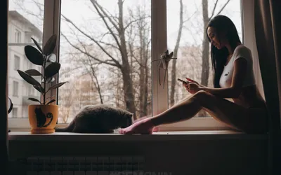 Девушка сидит на подоконнике, пьет из чашки и смотрит в окно. За окном  молния, гроза, город. Непогода, домашний уют, вкусный напиток - чай или  кофе Stock Photo | Adobe Stock