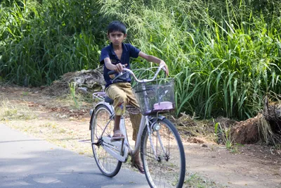 Маленький мальчик на велосипеде в городском парке | Премиум Фото