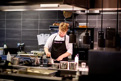 Шеф-повара представляя с ножом в их кухне ресторана Стоковое Изображение -  изображение насчитывающей кухня, варить: 77008565