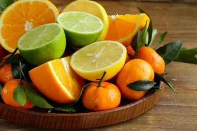 Обои на рабочий стол Цитрусовые фрукты: апельсины, мандарины, лимоны,  лаймы, нарезанные лежат в деревянной чашке, обои для рабочего стола,  скачать обои, обои бесплатно