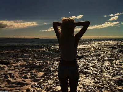Девушка на берегу моря со спины с поднятыми вверх руками — Фотографии для  аватара