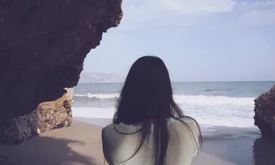 Девушка смотрит на шторм в море