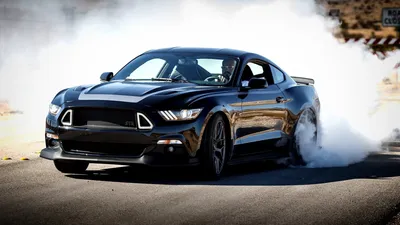 Черный ford mustang на фоне ангара - обои на телефон