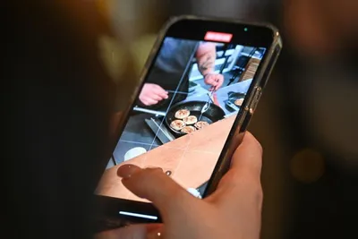 африканский американец ест вкусный гамбургер смотрит в телефон Стоковое  Изображение - изображение насчитывающей конец, красиво: 221998387
