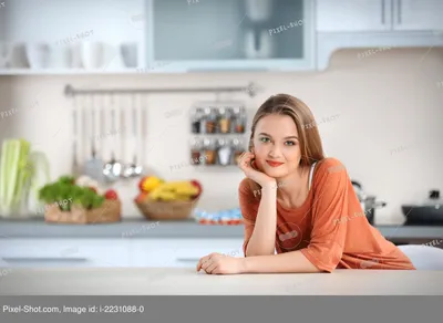 Уставшая женщина повар сидит за столом на кухне Stock Photo | Adobe Stock